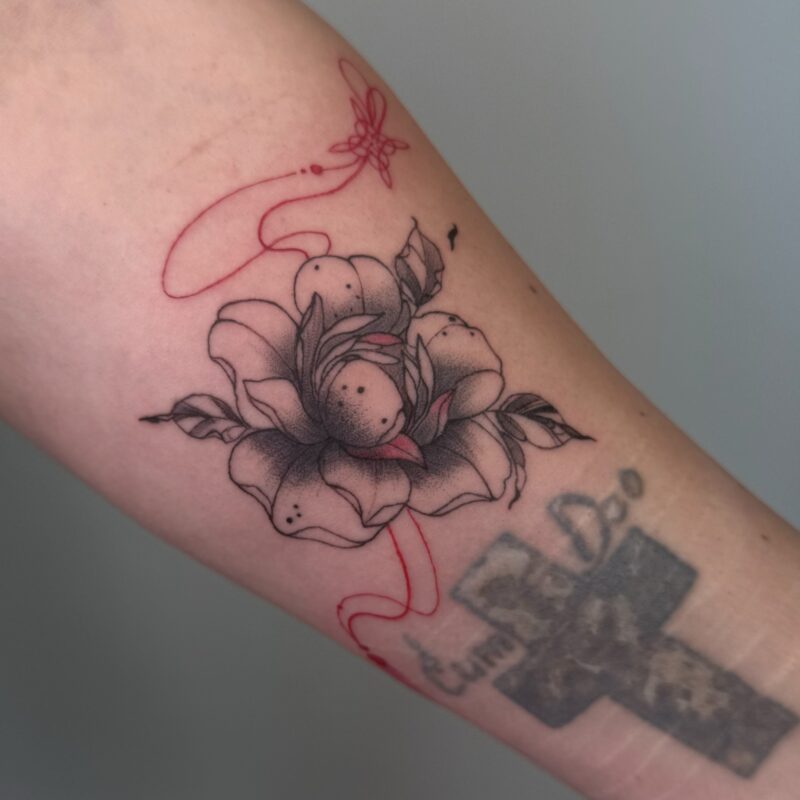 Тату квітка з червоною стрічкою на руці — робота учениці Skaty.Tattoo